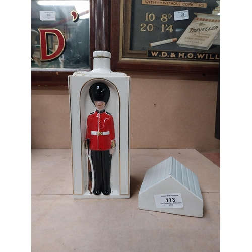 113 - Ceramic bottle in the form of Coldstream Guard. {25 cm H x 9 cm W x 9 cm D}.