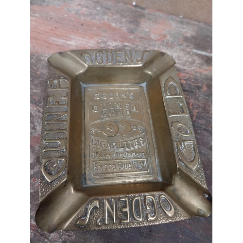 1242 - Two Odgens Guinea Gold brass ashtrays. {2 cm H x 12 cm W x 10 cm D}.