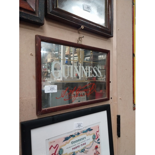 253 - Guinness advertising mirror in wooden frame. {21cm H x 32 cm W}.