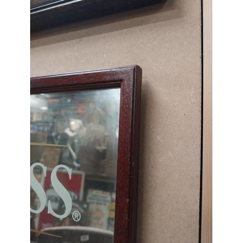 253 - Guinness advertising mirror in wooden frame. {21cm H x 32 cm W}.