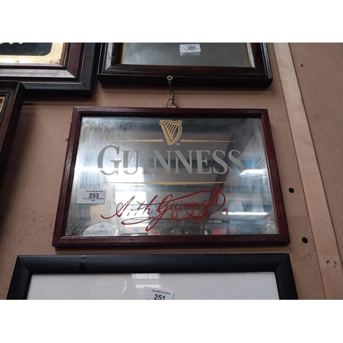 253 - Guinness advertising mirror in wooden frame. {21cm H x 32 cm W}.