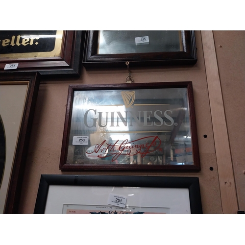 253 - Guinness advertising mirror in wooden frame. {21cm H x 32 cm W}.