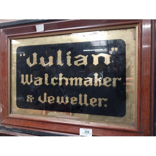 254 - Julian Watchmaker & Jeweller reverse painted glass framed advertising sign {41 cm H x 56 cm W}.