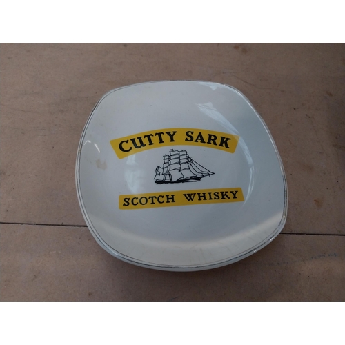 296 - Two Cutty Sark Scotch Whiskey Wade ceramic advertising ashtrays. {2 cm H x 14 cm W x 14 cm D}.