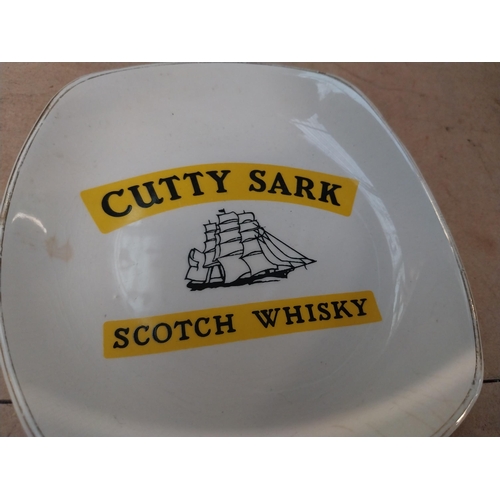 296 - Two Cutty Sark Scotch Whiskey Wade ceramic advertising ashtrays. {2 cm H x 14 cm W x 14 cm D}.