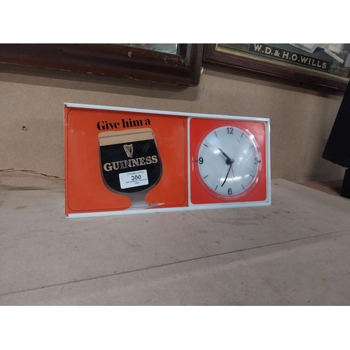 300 - Guinness Give Him a Guinness perspex light up advertising clock. {15 cm H  x 51 cm W x 5 cm D}.