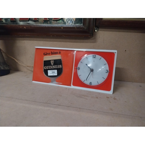 300 - Guinness Give Him a Guinness perspex light up advertising clock. {15 cm H  x 51 cm W x 5 cm D}.