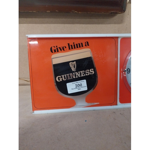 300 - Guinness Give Him a Guinness perspex light up advertising clock. {15 cm H  x 51 cm W x 5 cm D}.