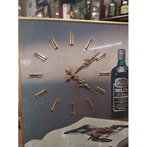 557 - 1970's Bell's Whiskey battery operated advertising wall clock. {27 cm H x 51 cm W}.