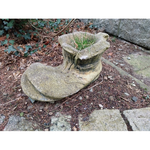 1049 - Weathered composition planter in the form of a boot. {23 cm H x 46 cm W x 23 cm D}.