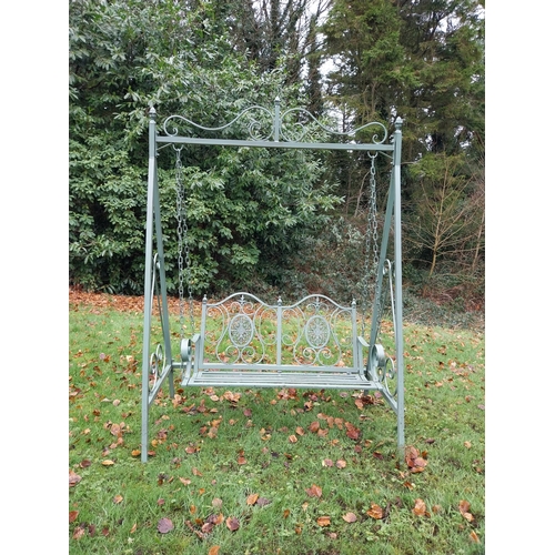 1053 - Decorative wrought iron garden swing. {207 cm H x 147 cm W x 90 cm D}.