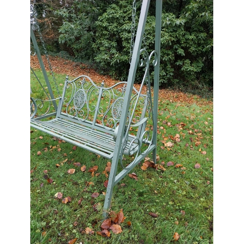 1053 - Decorative wrought iron garden swing. {207 cm H x 147 cm W x 90 cm D}.