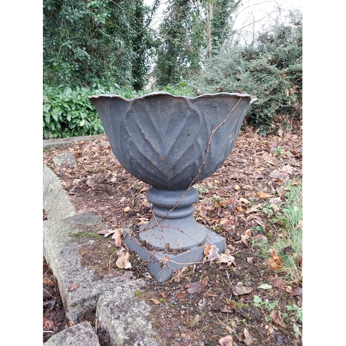 1068 - Pair of cast iron garden urns decorated with acanthus leaves, mounted on stone bases. {33 cm H x 60 ... 