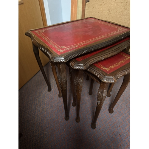 1087 - Nest of three 1970's mahogany tables with tooled leather tops, raised on Queen Anne legs. { 53cm H X... 