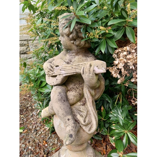 12 - Weathered composition figure of Cherub with musical instrument. {100 cm H x 46 cm W x 30 cm D}.