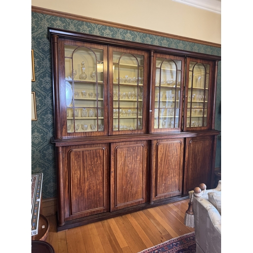 257 - Willliam IV mahogany four door glazed bookcase with turned columns above four blind doors, raised on... 