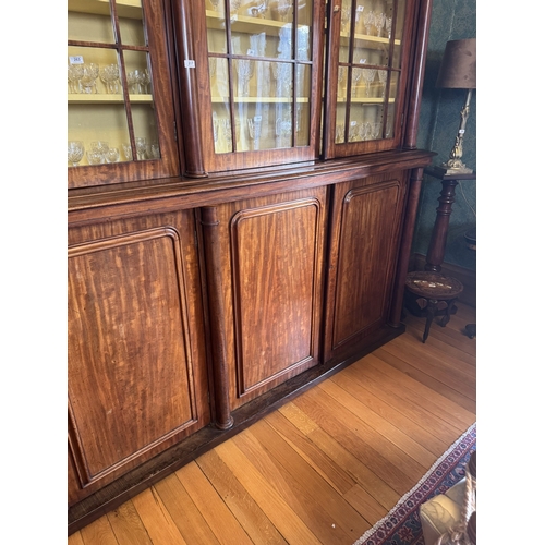 257 - Willliam IV mahogany four door glazed bookcase with turned columns above four blind doors, raised on... 