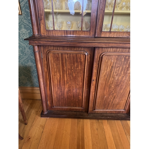 257 - Willliam IV mahogany four door glazed bookcase with turned columns above four blind doors, raised on... 