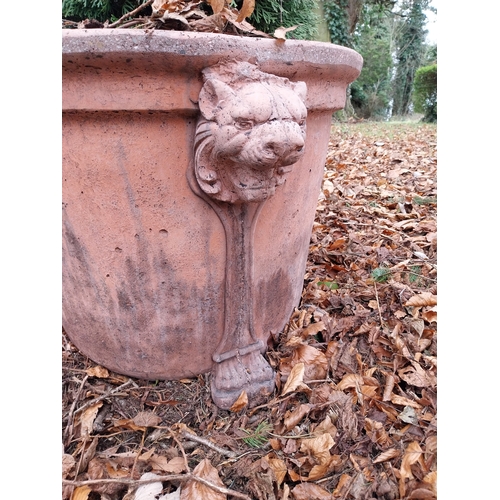 29 - Pair of moulded terracotta urns decorated with lion�s masks on lion�s paw feet with coniferous tree.... 