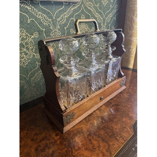 296 - Edwardian oak tantalus with brass mounts and three cut glass decanters. {35 cm H x 42 cm W x 16 cm D... 