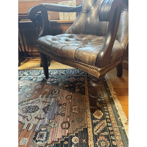 320 - Pair of good quality deep buttoned leather upholstered library chairs, raised on turned tapered legs... 