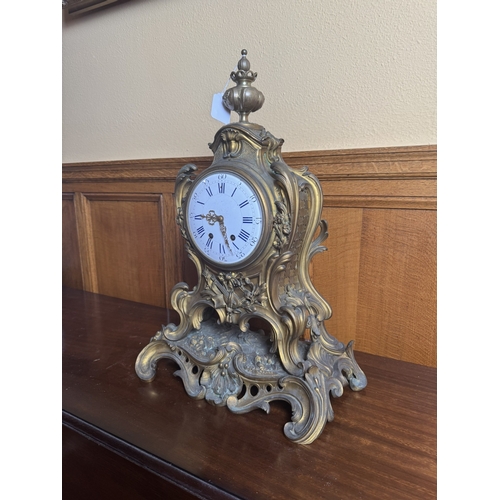 58 - 19th. C. gilded brass mantle clock decorated with musical instruments and surmounted with an urn, in... 