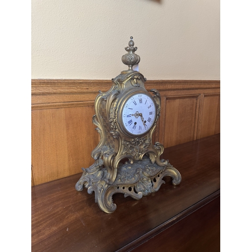 58 - 19th. C. gilded brass mantle clock decorated with musical instruments and surmounted with an urn, in... 