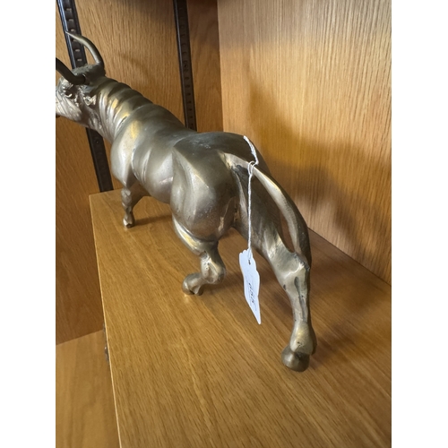 655 - Brass model of a bull. { 22cm H X 38cm W X 10cm D }.