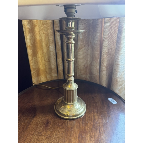 664 - Brass  table lamp, in the form of a candlestick with cloth shade. { 58cm H X 35cm W X 27cm D }.