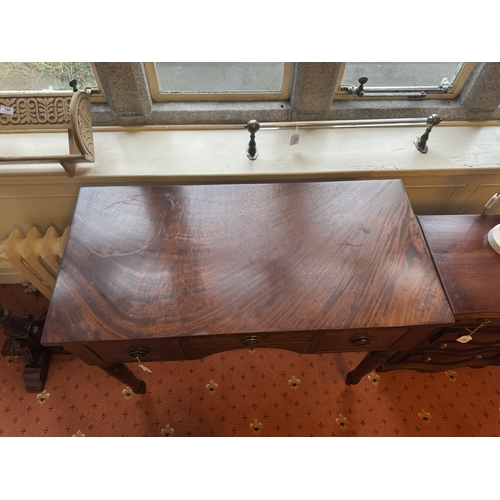 712 - Georgian mahogany kneehole desk, the short centre drawer flanked by two deep drawers, raised on turn... 