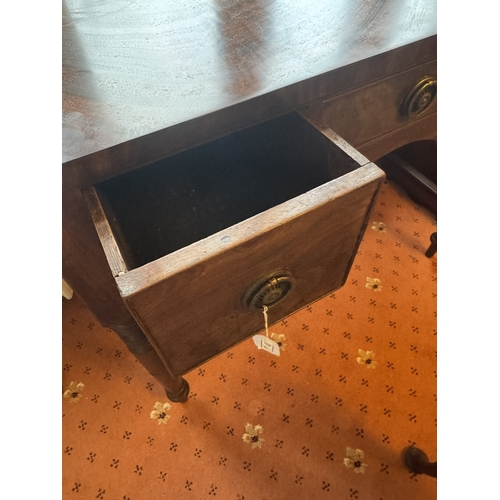 712 - Georgian mahogany kneehole desk, the short centre drawer flanked by two deep drawers, raised on turn... 