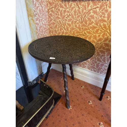 723 - Oriental oak occasional table, the circular top carved with HoHo birds, raised on three spiral legs.... 