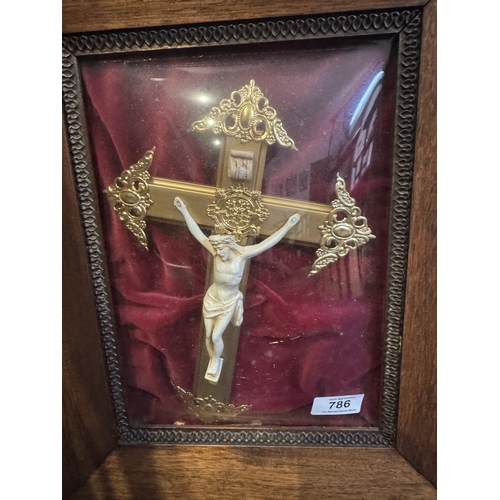 786 - Brass crucifix resting on red velvet, mounted in a glazed oak frame {43 cm H x 35 cm W}.