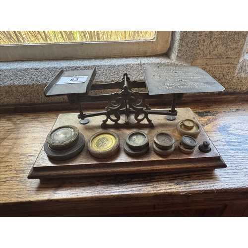 83 - 19th. C. brass and oak postal scales with brass weights. { 10cm H X  24cm W X 13cm D }.