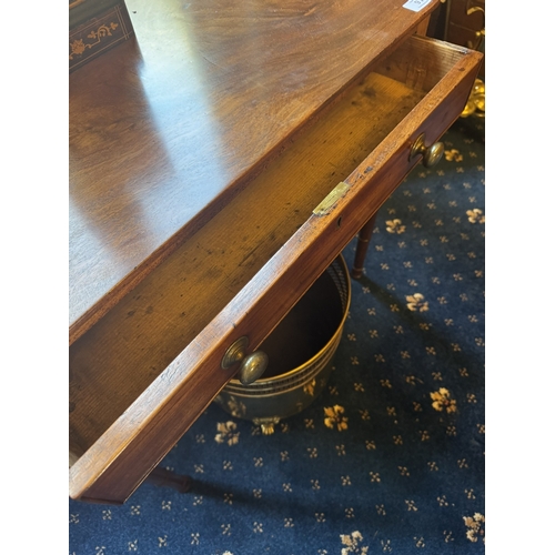 91 - Georgian mahogany writing table with single long drawer in the frieze, raised on turned legs. { 63cm... 