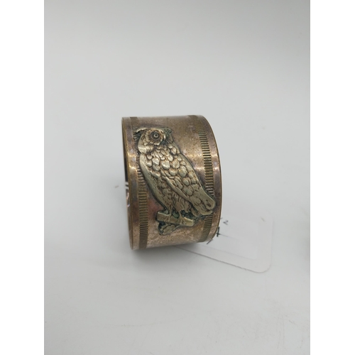 1010 - Two silver plated napkin rings . Square holder stamped WMFN x/o OX. Circular holder decorated with a... 