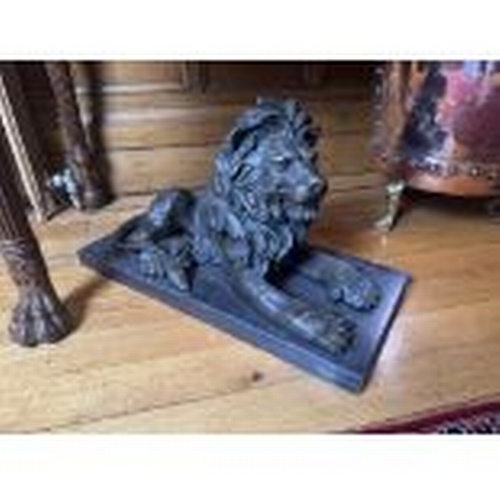 68 - Pair of recumbent bronze lions, mounted on marble bases.