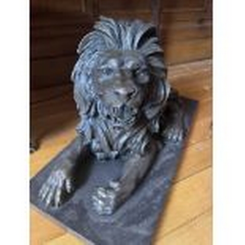 68 - Pair of recumbent bronze lions, mounted on marble bases.