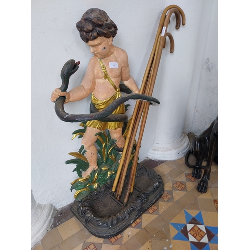 71 - Decorative cast iron stick stand mounted on cherub. { 84cm H X 48cm W X 26cm D }.