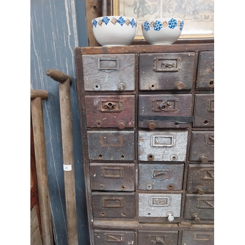35 - 20th C. oak bank of fifty drawers (two missing). {130 cm H x 90 cm W x 35 cm D}.