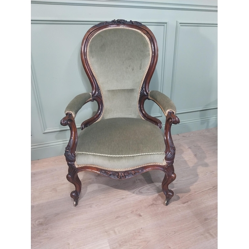 610 - Victorian carved rosewood and upholstered armchair on cabriole legs. {108 cm H x 68 cm W x 64 cm D].