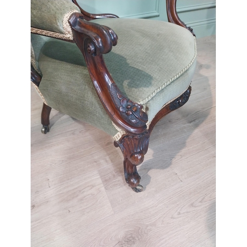 610 - Victorian carved rosewood and upholstered armchair on cabriole legs. {108 cm H x 68 cm W x 64 cm D].