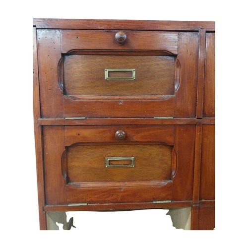 40 - Early 20th C. stained pine office cabinet with twenty one drop down doors with brass mounts. {171 cm... 