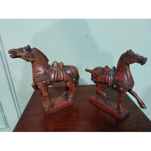 45 - Two carved painted pine models of Oriental Horses. {27 cm H x 28 cm W x 12 cm D}.