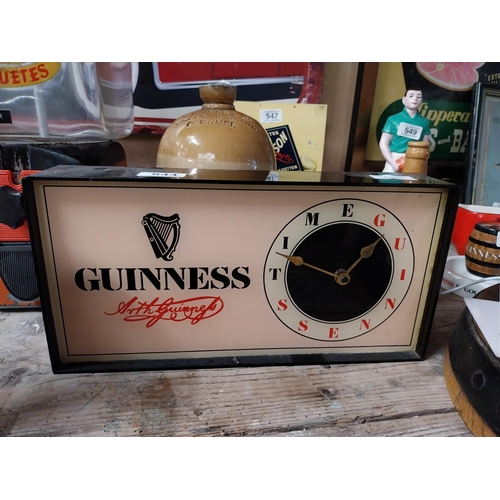 Guinness perspex battery operated clock. {18 cm H x 35 cm W x 7 cm D}.