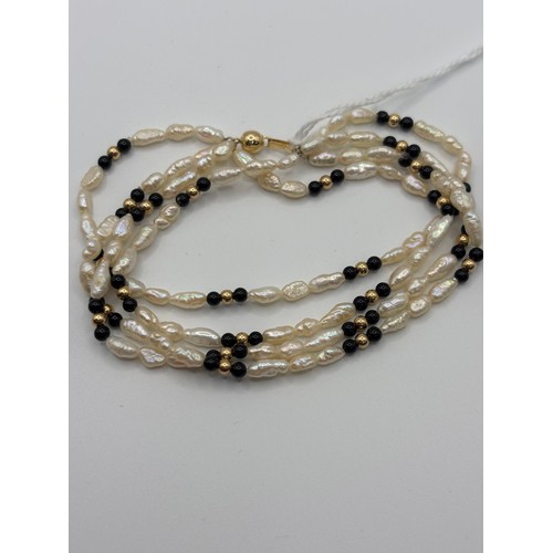 563 - 14ct gold seed & onyx  4 strand bracelet. 7 inch. Available to view on request.