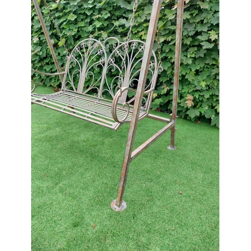 616 - Decorative bronzed painted wrought iron garden swing. {217 cm H x 147 cm W x 96 cm D}.