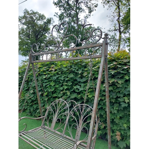 616 - Decorative bronzed painted wrought iron garden swing. {217 cm H x 147 cm W x 96 cm D}.
