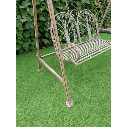 616 - Decorative bronzed painted wrought iron garden swing. {217 cm H x 147 cm W x 96 cm D}.