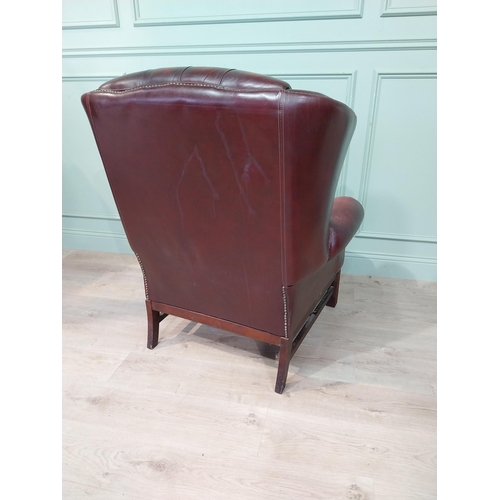 15 - Oxblood leather deep buttoned Chesterfield wingback armchair. {106 cm H x 90 cm W x 90 cm D}.